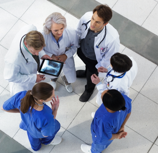 group of doctors talking around tablet