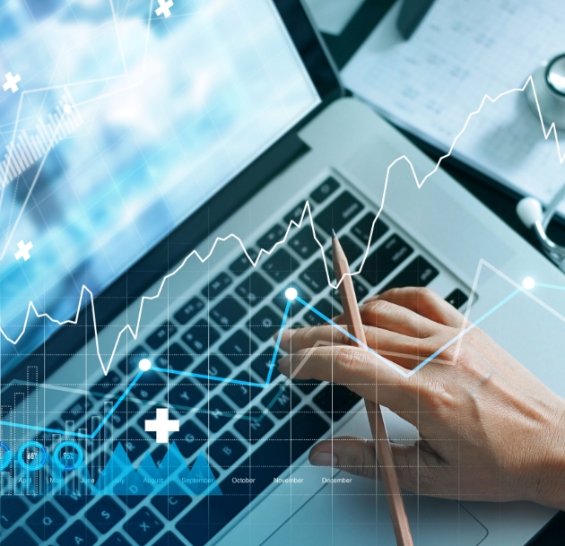 artistic image on hand typing on laptop with graphs superimposed over top