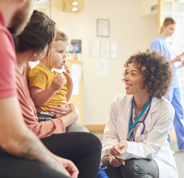 doctor kneeling to speak with child