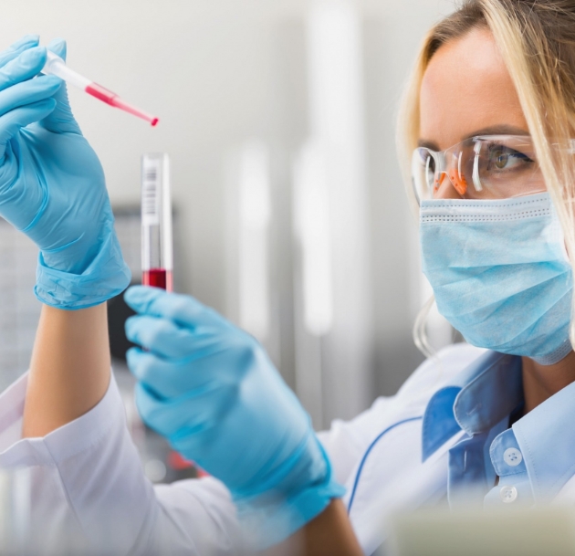 woman with PPE using test tube