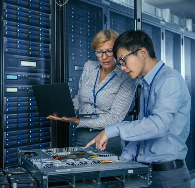 Two engineers looking at the inside of a computer